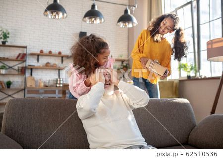 Cute dark-skinned girls making a surprise for their granddad Cute dark-skinned girls making a surprise for their granddad 62510536
