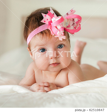 Newborn child relaxing in bed. 62510647