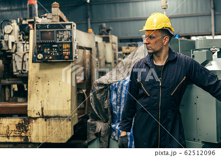 Portrait handsome worker with safety suit and old machine in factory. 62512096