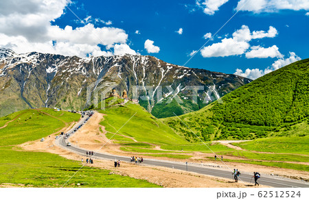 Tourists walking towards Gergeti Trinity Church under Mount Kazbegi in Georgia 62512524