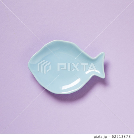 Fish shaped dish isolated on purple background 62513378
