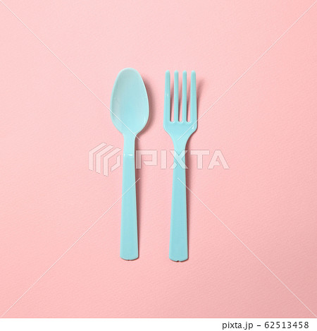 Blue plastic fork and spoon isolated on pink background 62513458