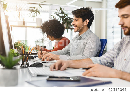 Colleagues working in front of computers in coworking space 62515041