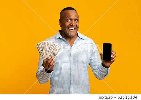 Mature african man holding lots of money and cellphone 62515304