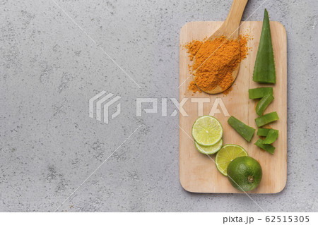 A powder of turmeric, sliced Aloe vera and lime on a wood A powder of turmeric, sliced Aloe vera and lime on a wood 62515305