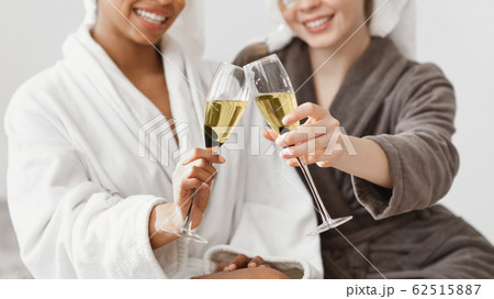 Cropped of two multiethnic ladies cheering with glasses of champagne 62515887