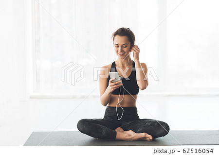 Woman Relaxing With Smartphone At Yoga Class 62516054