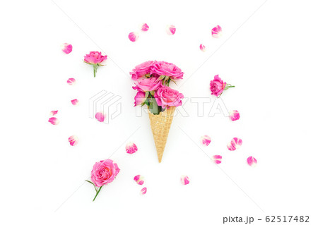 Floral composition with roses flowers in wafle cone and petals on white. Flat lay, top view. 62517482