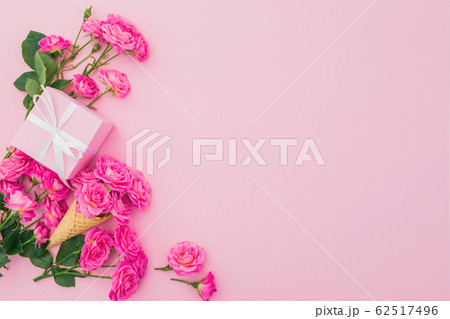 Floral frame of pink roses flowers and gift box on pink background. Flat lay. Happy birthday Floral frame of pink roses flowers and gift box on pink background. Flat lay. Happy birthday 62517496