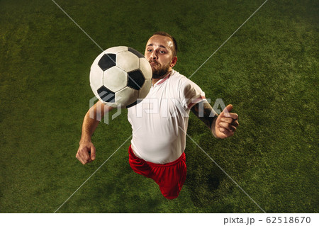 Top view of caucasian football or soccer player on green background of grass Top view of caucasian football or soccer player on green background of grass 62518670