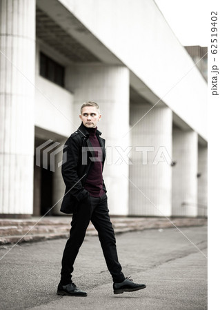 Stylish man in black trenchcoat 62519402
