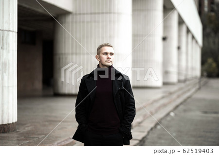 Stylish man in black trenchcoat 62519403