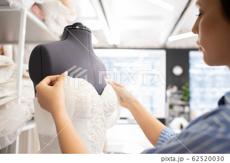 Seamstress Working On Wedding Dress 62520030