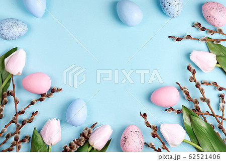 Easter willow wreath, white tulips and blue pink Easter eggs on blue background. Top view, copy space Easter willow wreath, white tulips and blue pink Easter eggs on blue background. Top view, copy space 62521406