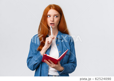 Talented, creative good-looking redhead woman writing poem, story, taking notes, prepare grocery list, gasping recall, remember something writing-down in notebook, white background Talented, creative good-looking redhead woman writing poem, story, taking notes, prepare grocery list, gasping recall, remember something writing-down in notebook, white background 62524090