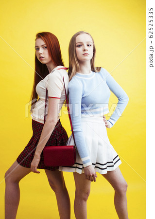 lifestyle people concept: two pretty young school teenage girls having fun happy smiling on yellow background 62525335