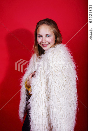 young pretty teenage girl on bright red background, happy smiling lifestyle people concept young pretty teenage girl on bright red background, happy smiling lifestyle people concept 62525355