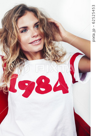 young pretty teenage hipster girl posing emotional happy smiling on white background, lifestyle people concept 62525453