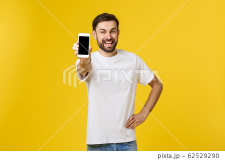 Close up portrait of attractive young model with trendy hairstyle and outfit, presenting new smartphone for advertising. Close up portrait of attractive young model with trendy hairstyle and outfit, presenting new smartphone for advertising. 62529290