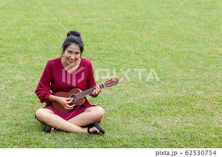 Beautiful young asian woman is playing ukulee 62530754