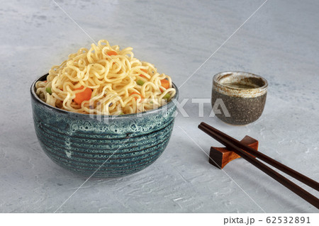 Instant noodles bowl with carrot and scallions, with chopsticks and sake, vegetable soba bowl with a place for text Instant noodles bowl with carrot and scallions, with chopsticks and sake, vegetable soba bowl with a place for text 62532891