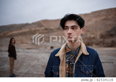 Dramatic portrait of a young brunette guy in 62534119