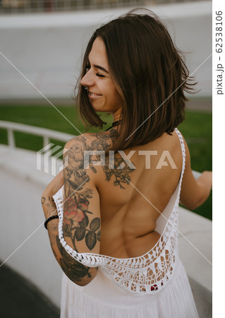 Slender sexy woman showing off her shapely back standing in a white dress, look over her shoulder Slender sexy woman showing off her shapely back standing in a white dress, look over her shoulder 62538106