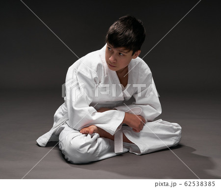 a teenager dressed in martial arts clothing poses a teenager dressed in martial arts clothing poses 62538385