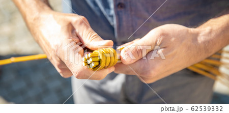 a man knitting his Easter whip from a rod a man knitting his Easter whip from a rod 62539332