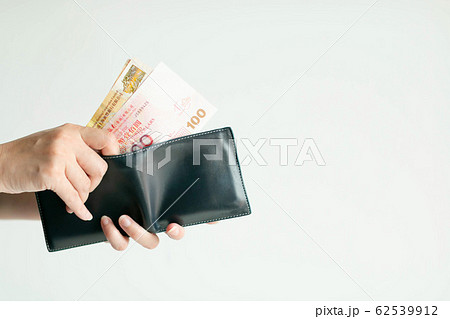 Hands picking Hong Kong money (Dollar Hong Kong or HKD) from short wallet for payment. or 62539912