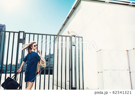 Stylish lady in blue dress with black leather handbag dancing ne Stylish lady in blue dress with black leather handbag dancing ne 62541321