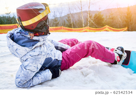 Girl with snowboard in snowy mountains 62542534