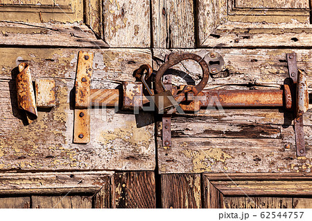 Old wooden door with iron rusty latch and padlock 62544757