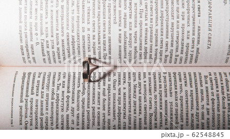 Wedding ring between the pages of an book with the sunlight casting a heart shaped shadow 62548845