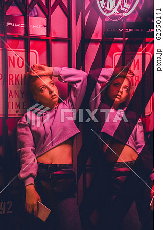 Nihgtlife. Teen girl leaning back isolated on club wall mirror reflection looking up pensive 62550141