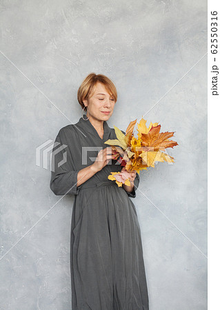Mature woman with short ginger hair holding fall Mature woman with short ginger hair holding fall 62550316