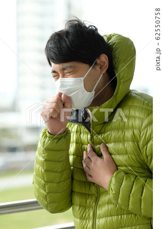 屋外で衛生マスクをして咳をしている日本人男性のウエストアップ横顔 屋外で衛生マスクをして咳をしている日本人男性のウエストアップ横顔 62550758