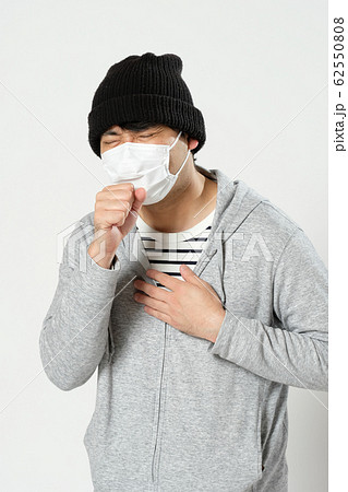 衛生マスクをしてニット帽をかぶって咳をして苦しそうな日本人男性のウエストアップ横顔 衛生マスクをしてニット帽をかぶって咳をして苦しそうな日本人男性のウエストアップ横顔 62550808