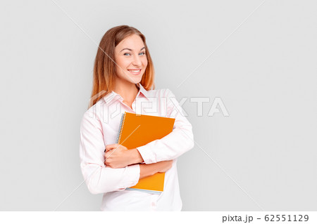 Freestyle. Young businesswoman standing isolated on white with notebook smiling joyful 62551129
