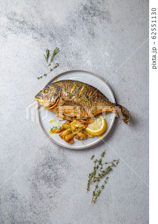 Grilled sea bream or dorada on gray plate. Gray background 62551130