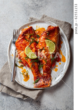 Baked red sea bass on kraft white plate, concrete background. 62551153