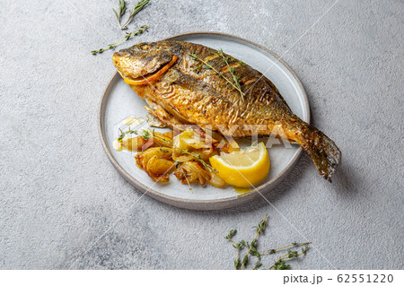 Grilled sea bream or dorada on gray plate. Gray background Grilled sea bream or dorada on gray plate. Gray background 62551220