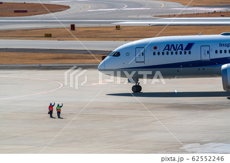 離陸する飛行機を見送るグランドハンドリングスタッフ 62552246