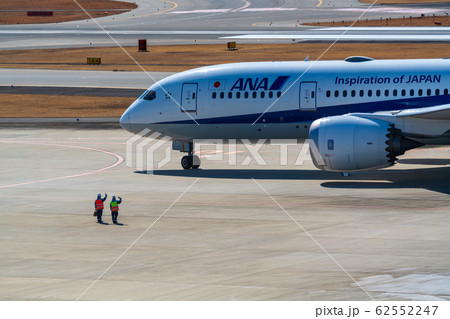 離陸する飛行機を見送るグランドハンドリングスタッフ 62552247