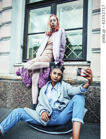 Two teenage girls infront of university building smiling, having fun, lifestyle real people concept 62552717