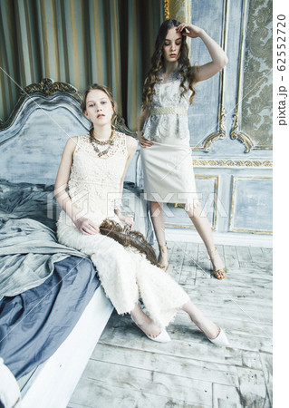 two pretty twin sister blond curly hairstyle girl in luxury house interior together, rich young people concept 62552720