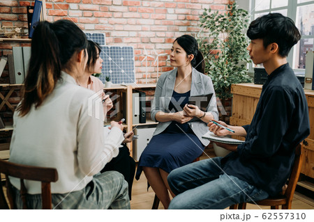 employees sit in circle in coworking space 62557310