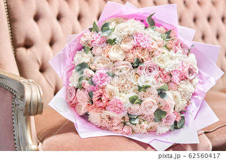 Beautiful bouquet of mixed flowers on a vintage sofa. the work of the florist at a flower shop. Delivery fresh cut flower. European floral shop. 62560417