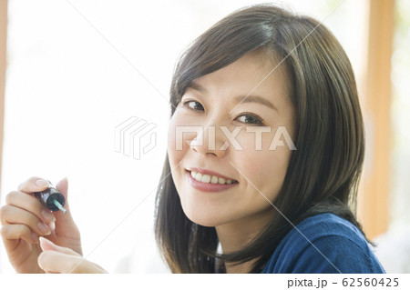 マニキュアを塗る若い女性 マニキュアを塗る若い女性 62560425