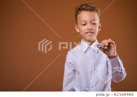 Young boy as businessman against brown background Young boy as businessman against brown background 62566460